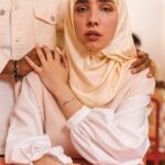 A woman in a hijab receives comfort from a supportive companion in an emotional moment.