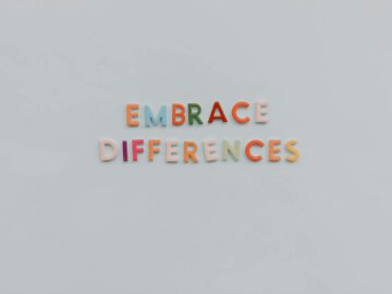 Colorful letters spelling 'Embrace Differences' on a minimalist gray background highlighting inclusivity and diversity.
