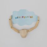 Abstract concept of mindfulness with a wooden mannequin holding a blue cloud shape.