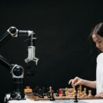A woman plays chess against a robotic arm, showcasing AI innovation in a modern setting.