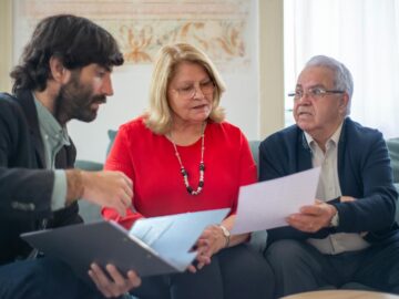 Senior couple consulting with a professional advisor, discussing documents indoors.