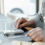 A hand uses a digital scale with a beaker in a laboratory setting. Perfect for scientific and educational content.