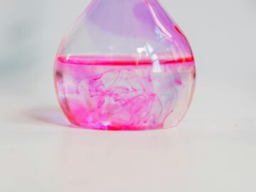 Close-up of pink dye diffusing in a laboratory flask, perfect for science and chemistry themes.
