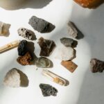 Various minerals and rocks arranged on a sunlit table, showcasing natural textures and colors.
