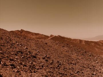 A barren and rocky desert landscape reminiscent of the planet Mars with a warm, dusty sky.