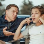 A father and teenage son having an intense conversation, capturing the essence of family dynamics and communication.