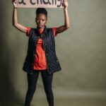 Confident activist woman with a protest sign demanding change.