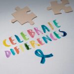 Colorful 'Celebrate Differences' message with puzzle pieces for awareness.