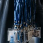 Close-up of blue lanyards with identification badges at an event.
