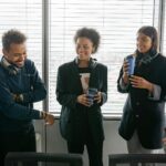 A diverse group of call center agents enjoying a casual break in the office, sharing laughs and hot drinks.