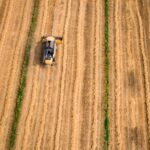 aerial photography of yellow cultivator on brown field
