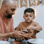 A father and son enjoying a traditional meal together during Ramadan, symbolizing family bonding.
