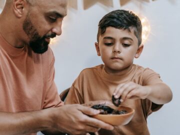A father and son enjoying a traditional meal together during Ramadan, symbolizing family bonding.