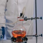 Scientist conducting experiment using laboratory glassware and chemicals.