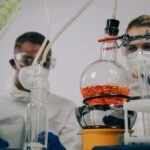 Two scientists in protective gear conducting experiments in a laboratory setting.