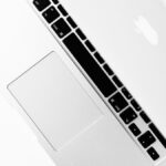 Aerial shot of a sleek silver laptop keyboard with open screen, ideal for tech themes.