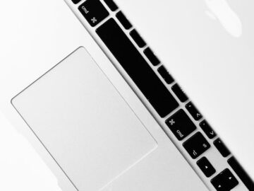 Aerial shot of a sleek silver laptop keyboard with open screen, ideal for tech themes.