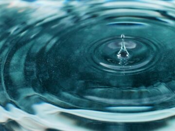 A mesmerizing close-up image of a water droplet creating ripples on the surface.