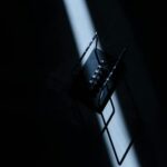 Newton's cradle in a dark room with striking light, showcasing physics concepts.