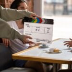 Film crew sets up with a clapperboard on a movie set, capturing a candid moment.