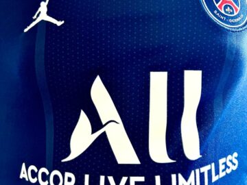 Detailed view of Paris Saint-Germain jersey with sponsor logos and design elements.