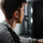 A man sitting in front of a computer monitor