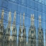 A reflection of a building in the glass of another building