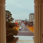 vehicles on street between buildings view from window
