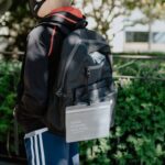 person in black leather jacket wearing white helmet