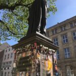black statue near green tree during daytime