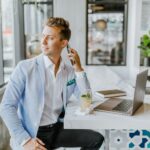 man sitting beside white wooden table
