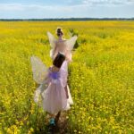 two girls walking near flower field