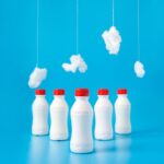 five white plastic bottles on blue surface