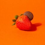 a close up of a strawberry on an orange background