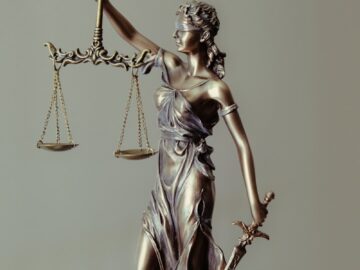 woman in gold dress holding sword figurine