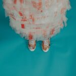 person wearing brown-and-white lace-up shoes