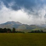 A grassy field with mountains in the background