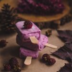 selective focus photography of thee purple ice pops near pine cones