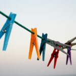 seven assorted-color clothes pegs hanging on rope