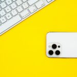 a white iphone sitting on top of a yellow table