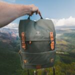 person holding black and brown Vinta backpack