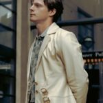 A man in a suit and tie standing on a sidewalk