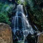 water falls on brown rocky mountain
