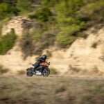 man wearing helmet riding motorcycle near cliff