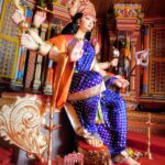 woman in blue and gold sari dress sitting on gold chair
