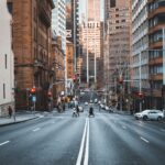 people crossing the street surrounded with high-rise buildings