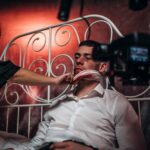 man in white dress shirt holding woman in black dress