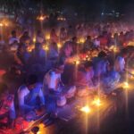 A large group of people sitting around candles