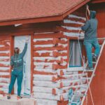 a man standing on a ladder next to a woman