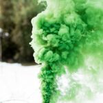 shallow focus photography of canister producing green smoke